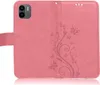 A pink flip case for a smartphone, open to show the interior and a floral embossed design. Produktbild-Vorschau
