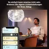 A man is holding a smartphone and a glass, looking up at a smart light fixture. Náhled obrázku produktu