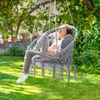 A woman relaxing in a hanging chair in a garden. Produktbild-Vorschau