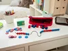 A desk with educational math manipulatives, including beads on a string, counting cubes, and counters. Anteprima dell’immagine prodotto