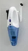 A white and blue handheld vacuum cleaner mounted on a textured wall with a charging dock and an attachment. Podgląd zdjęcia produktu