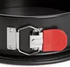 A close-up view of the latch mechanism on a black springform cake pan. Produktbild-Vorschau