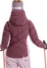 A woman wearing a ski jacket and pants, holding ski poles. Produktbild-Vorschau