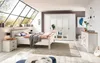 A bedroom with a bed, wardrobe, and nightstand, bathed in natural light from a large window. Podgląd zdjęcia produktu