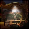An outdoor patio scene at night, with a lit umbrella and seating. Produktbild-Vorschau