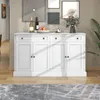 A white sideboard with four doors and three drawers is displayed in a room with artwork on the wall and a plant in the background. Produktbild-Vorschau