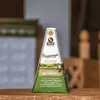 A triangular wedge of Parmigiano Reggiano cheese in its packaging, placed on a wooden surface. Produktbild-Vorschau