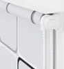 A close-up view of a white roller blind with a square pattern on the fabric, attached to a white wall. Náhľad obrázku produktu