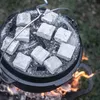 A close-up view of charcoal briquettes being heated in a Dutch oven over a fire. Produktbild-Vorschau
