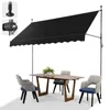 A black awning is extended over a dining table and chairs on a patio or balcony. Náhľad obrázku produktu