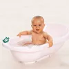 A baby is sitting in a pink bathtub with a green turtle-shaped thermometer. Anteprima dell’immagine prodotto