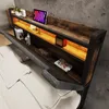 A bed with a headboard featuring shelves, lighting, and decorative items. Anteprima dell’immagine prodotto