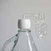 A close-up of a glass fermentation airlock attached to a white cap on a glass carboy. Produktbild-Vorschau