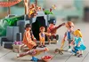 A group of Playmobil figures are gathered around a treehouse-like structure, with some playing music and others interacting with toy animals. Podgląd zdjęcia produktu