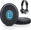 A pair of black ear pads for headphones, with a blue and white striped 'L' logo on one, and a pair of headphones in the background. Náhled obrázku produktu