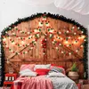 A bedroom decorated for Christmas with a wooden headboard, garlands, and festive bedding. Produktbild-Vorschau