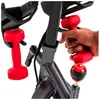 A hand is holding a red dumbbell next to a stationary bike. Voir les images du produit