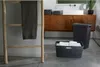A bathroom scene with laundry baskets and a towel rack. Produktbild-Vorschau