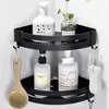 A black metal corner shelf in a bathroom, holding various toiletries and bath accessories. Produktbild-Vorschau