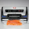 A vacuum sealer machine with a piece of salmon inside a vacuum bag. Produktbild-Vorschau