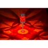 A red solar garden light projects a starburst pattern onto a surface. Produktbild-Vorschau