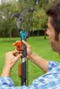 A man is holding and adjusting a gardening tool in an outdoor setting. Náhled obrázku produktu