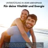 A couple is smiling and enjoying themselves on a beach. Produktbild-Vorschau