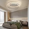 A modern bedroom with a bed, nightstands, and a ceiling light. Produktbild-Vorschau