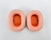 Two peach-colored ear pads with orange mesh interiors are laid out on a white background. Produktbild-Vorschau