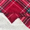 A close-up view of a red plaid sherpa blanket. Produktbild-Vorschau