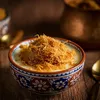 A close-up shot of a dessert in a decorative bowl, set on a wooden surface. Produktbild-Vorschau