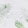 A close-up view of a white sheer curtain with a palm leaf pattern and a white ribbon tie. Produktbild-Vorschau