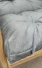 A close-up view of a gray cushion on a wooden chair frame. Produktbild-Vorschau