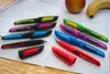 A collection of colorful fountain pens laid out on a notebook with some fruit in the background. Náhľad obrázku produktu