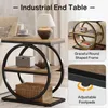 An industrial end table with a wooden top and black metal frame, featuring two shelves and decorative circular elements. The image includes close-ups highlighting features like the round frame and adjustable footpads, along with descriptive text. Anteprima dell’immagine prodotto