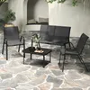 An outdoor patio scene with a four-piece furniture set. Anteprima dell’immagine prodotto