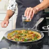 A person is cooking an omelet in a pan on a stovetop. Voir les images du produit