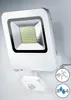A white LED floodlight with a motion sensor attached, mounted on a light gray wall. Produktbild-Vorschau