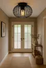 A hallway with a ceiling lamp, double doors, and a console table with decorative items. Anteprima dell’immagine prodotto