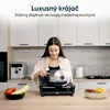 A woman is using a slicer in a modern kitchen. Náhľad obrázku produktu