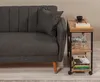 A dark gray sofa with a side table next to it, containing books, glasses, and a bottle of water. Voir les images du produit