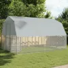 A large, silver-colored chicken coop with a gray roof sits on a green lawn, surrounded by trees. Produktbild-Vorschau