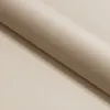 A close-up, angled view of a rolled-up piece of beige fabric. Voir les images du produit