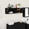 A black wall-mounted cabinet with its door open, displaying rolled towels inside. The cabinet is mounted on a white tiled wall above a black dresser with a white tiled backsplash. Bathroom accessories like soap dispensers, jars, and a plant are on top of t Anteprima dell’immagine prodotto