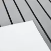 A close-up, angled view of a white sheet of material placed on a gray, slatted surface with black lines between the slats. Náhled obrázku produktu