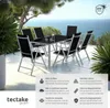 A patio dining set with a table and chairs is set up on a terrace overlooking the ocean. Voir les images du produit