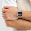 A person's arm wearing a silver digital watch. Produktbild-Vorschau