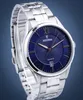 A close-up studio shot of a men's wristwatch with a blue dial and silver band. Náhľad obrázku produktu