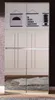 A tall, white wardrobe with mirrored doors, decorated with three framed posters at the top. The floor and a rug are reflected in the mirrored doors. Produktbild-Vorschau