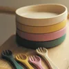 A stack of colorful bowls and matching spoons on a wooden surface. Náhľad obrázku produktu